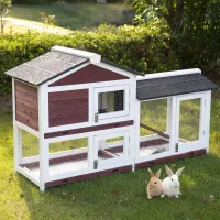 Large white and reddish-brown wooden rabbit hutch with wire run and two rabbits on grass