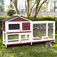 White and red wooden rabbit hutch with wire-mesh run, ramp, wheels and two rabbits on grass
