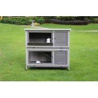 Two-storey gray rabbit hutch with wire-front doors, wooden panels, wheels, and two white rabbits