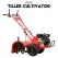 Red petrol rotary tiller with black engine, handlebars, large tires, and covered front tines on white