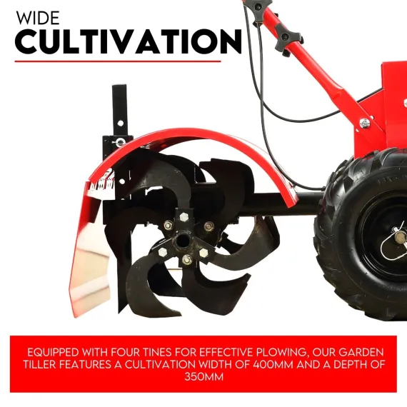 Side view of black rotary tines beneath a red protective cover beside the tiller's large tire