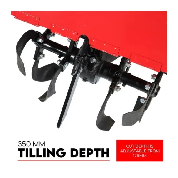 Close-up of multiple curved black tilling blades mounted beneath a red metal cover