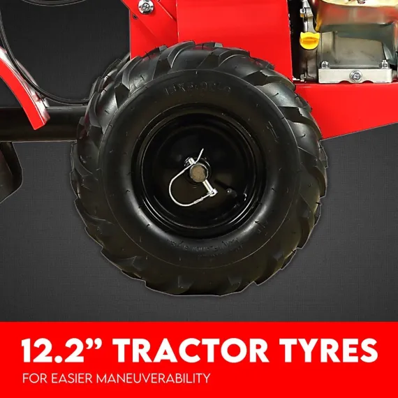 Close-up of a large black tractor-style tiller wheel with deep tread and metal retaining pin