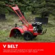 Red petrol rotary tiller with handlebars, engine, wheels and covered blades standing in a garden